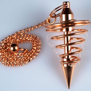 These copper pendulums are wire spirals with a pointed tip, with a copper chain and bead.