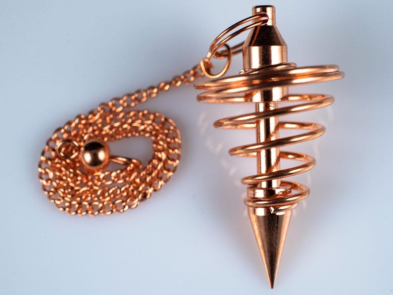 These copper pendulums are wire spirals with a pointed tip, with a copper chain and bead.