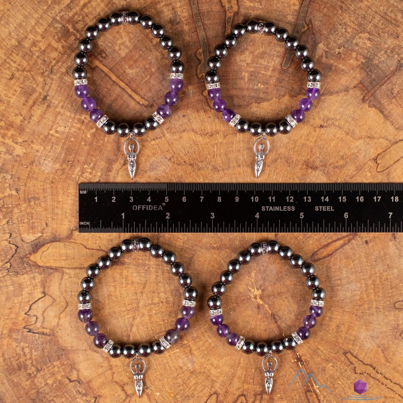 These purple Amethyst and grey Hematite crystal bracelets have round beads strung on elastic.  They feature a silver Goddess Charm.
Crystals are nature-made therefore each one is unique in appearance.