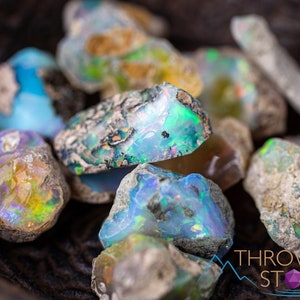 These raw Opal crystals are chunk shaped and rainbow colored with patches of tan matrix.
Crystals are nature-made therefore each one is unique in appearance.