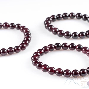 These maroon Garnet crystal bracelets have spherical beads strung on elastic for an endless bracelet.  
Crystals are nature-made therefore each one is unique in appearance.