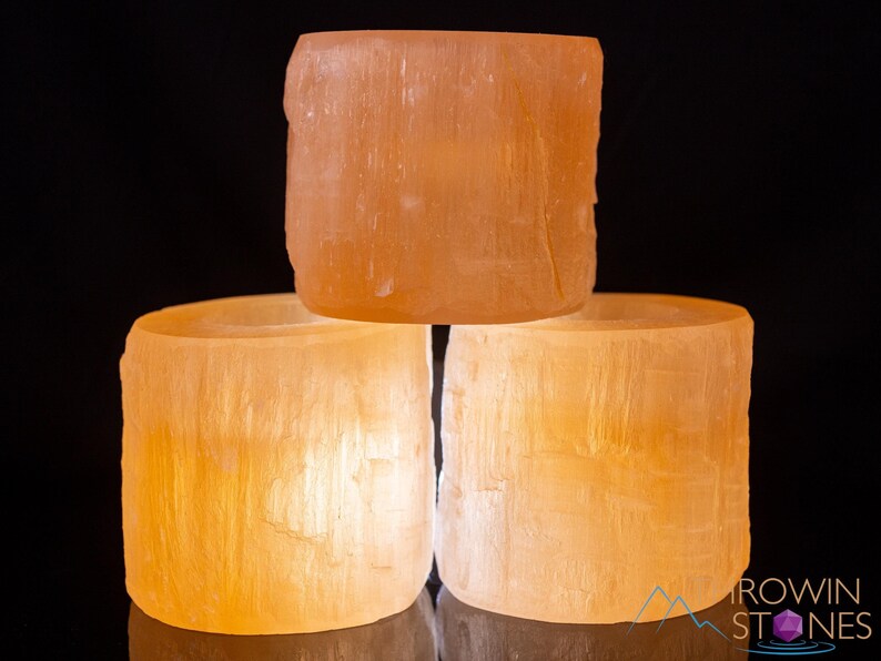 These peachy orange Selenite crystal carved raw cylindrical votive candle holders range in a variety of sizes.  
Crystals are nature-made therefore each one is unique in appearance.