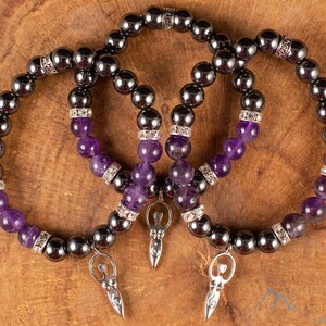 These purple Amethyst and grey Hematite crystal bracelets have round beads strung on elastic.  They feature a silver Goddess Charm.
Crystals are nature-made therefore each one is unique in appearance.