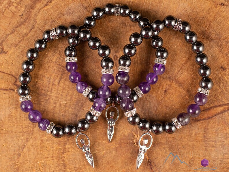 These purple Amethyst and grey Hematite crystal bracelets have round beads strung on elastic.  They feature a silver Goddess Charm.
Crystals are nature-made therefore each one is unique in appearance.