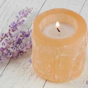These peachy orange Selenite crystal carved raw cylindrical votive candle holders range in a variety of sizes.  
Crystals are nature-made therefore each one is unique in appearance.