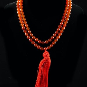 These red orange Carnelian necklaces have 108 sphere beads with a red tassel.  
Crystals are nature-made therefore each one is unique in appearance.