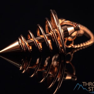 These copper pendulums are wire spirals with a pointed tip, with a copper chain and bead.
