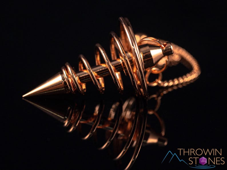 These copper pendulums are wire spirals with a pointed tip, with a copper chain and bead.