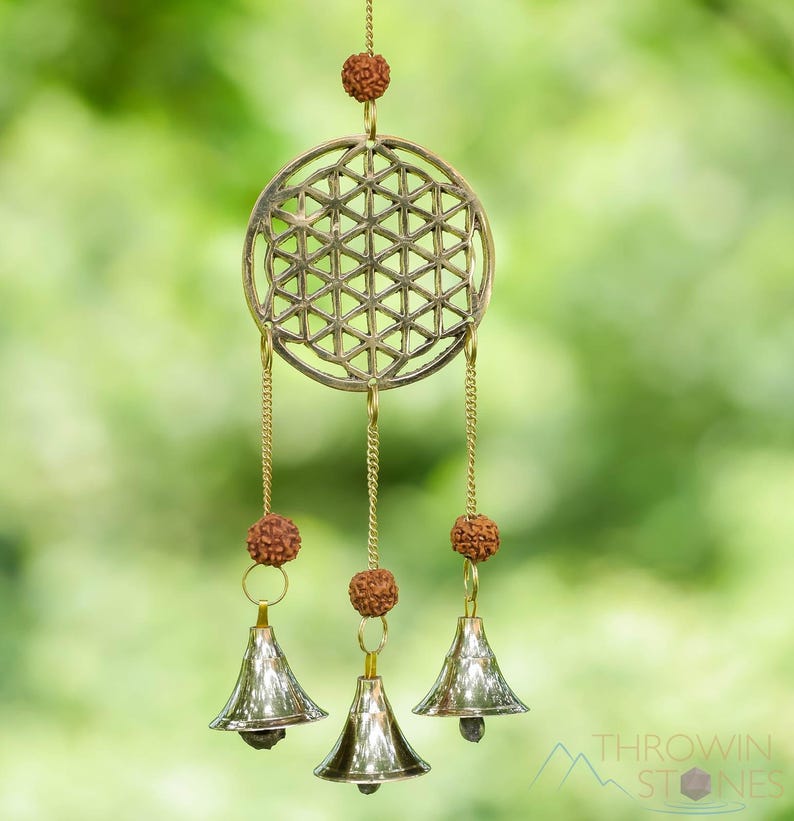These are small brass wind chimes in the shape of a disc with the "flower of life" sacred geometry design, with bells and Rudraksha beads.