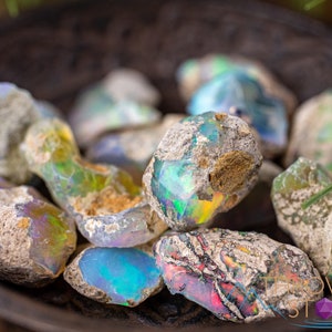 These raw Opal crystals are chunk shaped and rainbow colored with patches of tan matrix.
Crystals are nature-made therefore each one is unique in appearance.