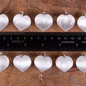 These chatoyant white Selenite crystal pendants are heart shaped, with a silver bail. 
Crystals are nature-made therefore each one is unique in appearance.