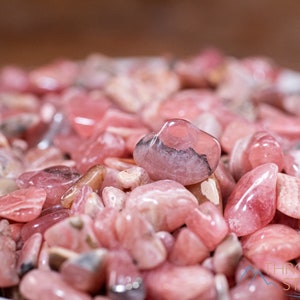 Rhodochrosite Crystal Chips. These stones are light pink to bright pink and often include a white banding. They are great for jewelry making and crystal decor. Each specimen is unique and varies in color, shape, and pattern. Listing has variations.