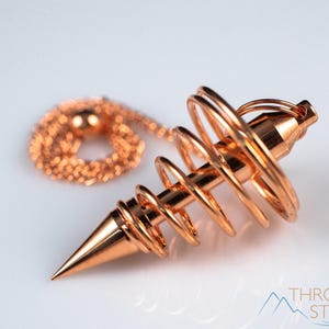 These copper pendulums are wire spirals with a pointed tip, with a copper chain and bead.