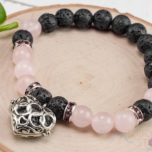 Op de afbeelding: Een roze en zwarte kralen armband met een zilveren hart bedel. De armband is gemaakt met lava steen en rozenkwarts kralen.