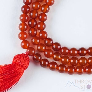 These red orange Carnelian necklaces have 108 sphere beads with a red tassel.  
Crystals are nature-made therefore each one is unique in appearance.