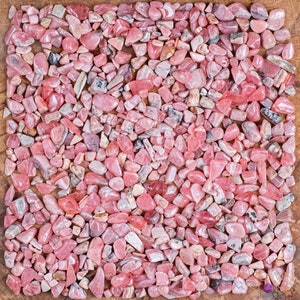 Rhodochrosite Crystal Chips. These stones are light pink to bright pink and often include a white banding. They are great for jewelry making and crystal decor. Each specimen is unique and varies in color, shape, and pattern. Listing has variations.