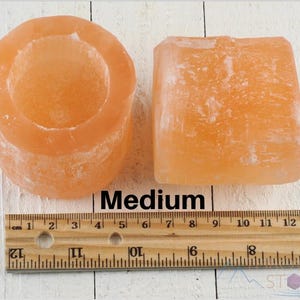 These peachy orange Selenite crystal carved raw cylindrical votive candle holders range in a variety of sizes.  
Crystals are nature-made therefore each one is unique in appearance.