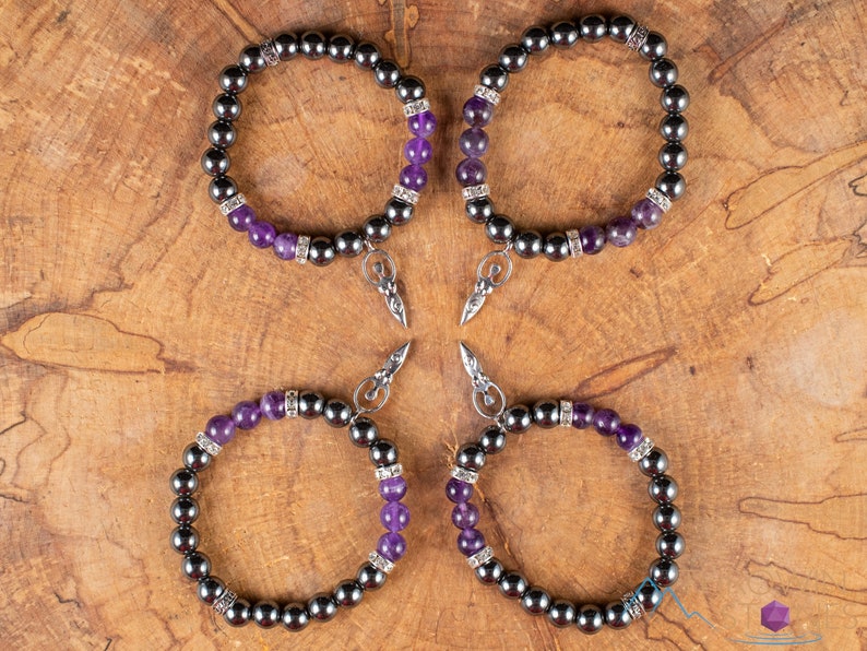 These purple Amethyst and grey Hematite crystal bracelets have round beads strung on elastic.  They feature a silver Goddess Charm.
Crystals are nature-made therefore each one is unique in appearance.