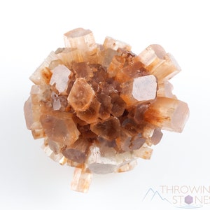 May include: A cluster of brown and clear aragonite crystals, with a rough, natural texture. The crystals are clustered together in a rounded shape, creating a unique and interesting display.