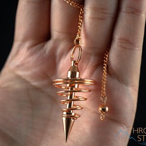 These copper pendulums are wire spirals with a pointed tip, with a copper chain and bead.
