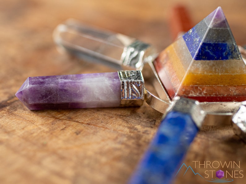 These crystal carved polished generators are a rainbow chakra crystal pyramid surrounded by 7 small points in each color of the rainbow chakras.
Crystals are nature-made therefore each one is unique in appearance.