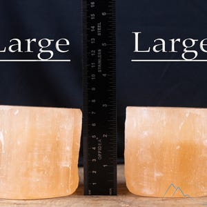 These peachy orange Selenite crystal carved raw cylindrical votive candle holders range in a variety of sizes.  
Crystals are nature-made therefore each one is unique in appearance.
