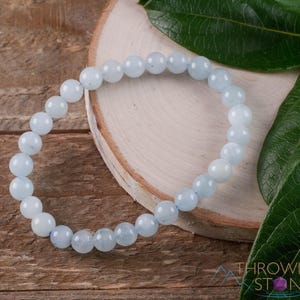 Handcrafted Aquamarine round beaded bracelet. These polished, blue beads are drilled and strung on elastic cord. Each crystal bracelet is unique in shape, color, and pattern and has a wrist circumference of about 6 to 7 inches. Listing has variations