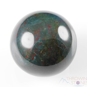 Natural Bloodstone crystal sphere, with wooden stand. This semi-precious, crystal ball is green with red hematite inclusions. Each crystal sphere is beautifully handcrafted, ethically sourced and comes with a wooden stand. This Listing has variations