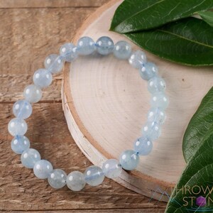 Handcrafted Aquamarine round beaded bracelet. These polished, blue beads are drilled and strung on elastic cord. Each crystal bracelet is unique in shape, color, and pattern and has a wrist circumference of about 6 to 7 inches. Listing has variations