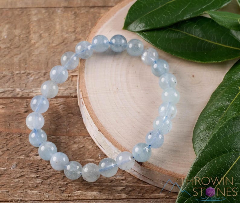 Handcrafted Aquamarine round beaded bracelet. These polished, blue beads are drilled and strung on elastic cord. Each crystal bracelet is unique in shape, color, and pattern and has a wrist circumference of about 6 to 7 inches. Listing has variations