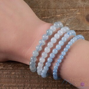 Handcrafted Aquamarine round beaded bracelet. These polished, blue beads are drilled and strung on elastic cord. Each crystal bracelet is unique in shape, color, and pattern and has a wrist circumference of about 6 to 7 inches. Listing has variations