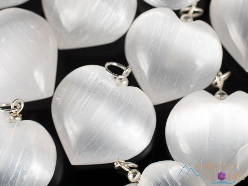 These chatoyant white Selenite crystal pendants are heart shaped, with a silver bail. 
Crystals are nature-made therefore each one is unique in appearance.