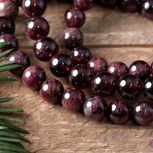 These maroon Garnet crystal bracelets have spherical beads strung on elastic for an endless bracelet.  
Crystals are nature-made therefore each one is unique in appearance.