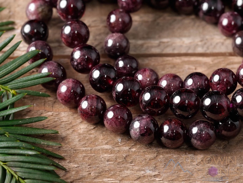 These maroon Garnet crystal bracelets have spherical beads strung on elastic for an endless bracelet.  
Crystals are nature-made therefore each one is unique in appearance.