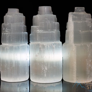 These white Selenite crystal carved raw tiered towers range in a variety of handheld sizes.  
Crystals are nature-made therefore each one is unique in appearance.