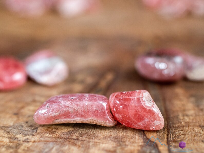 Rhodochrosite Crystal Chips. These stones are light pink to bright pink and often include a white banding. They are great for jewelry making and crystal decor. Each specimen is unique and varies in color, shape, and pattern. Listing has variations.