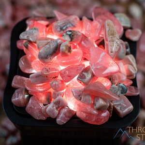 Rhodochrosite Crystal Chips. These stones are light pink to bright pink and often include a white banding. They are great for jewelry making and crystal decor. Each specimen is unique and varies in color, shape, and pattern. Listing has variations.