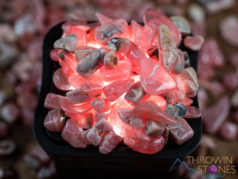 Rhodochrosite Crystal Chips. These stones are light pink to bright pink and often include a white banding. They are great for jewelry making and crystal decor. Each specimen is unique and varies in color, shape, and pattern. Listing has variations.