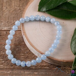 Handcrafted Aquamarine round beaded bracelet. These polished, blue beads are drilled and strung on elastic cord. Each crystal bracelet is unique in shape, color, and pattern and has a wrist circumference of about 6 to 7 inches. Listing has variations