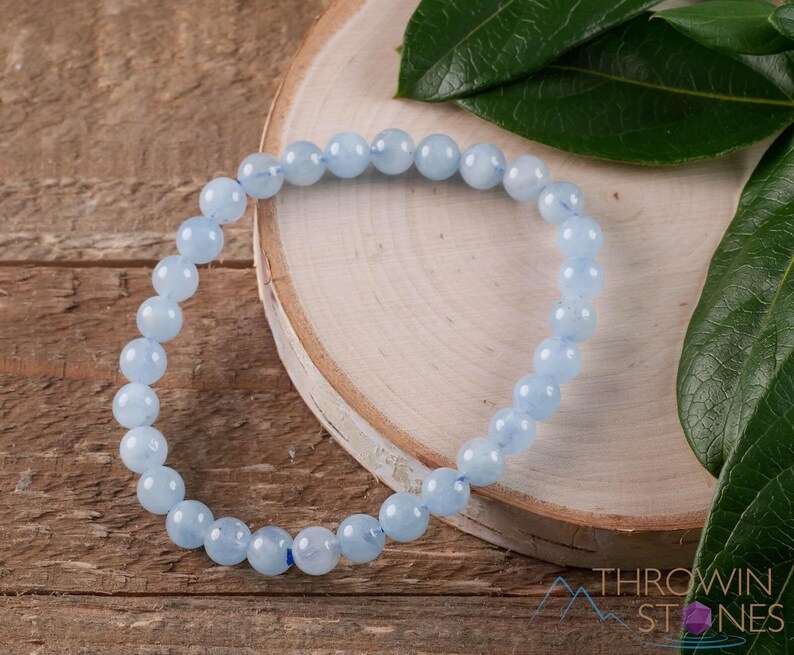 Handcrafted Aquamarine round beaded bracelet. These polished, blue beads are drilled and strung on elastic cord. Each crystal bracelet is unique in shape, color, and pattern and has a wrist circumference of about 6 to 7 inches. Listing has variations