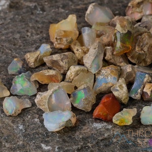 These raw Opal crystals are chunk shaped and rainbow colored with patches of tan matrix.
Crystals are nature-made therefore each one is unique in appearance.