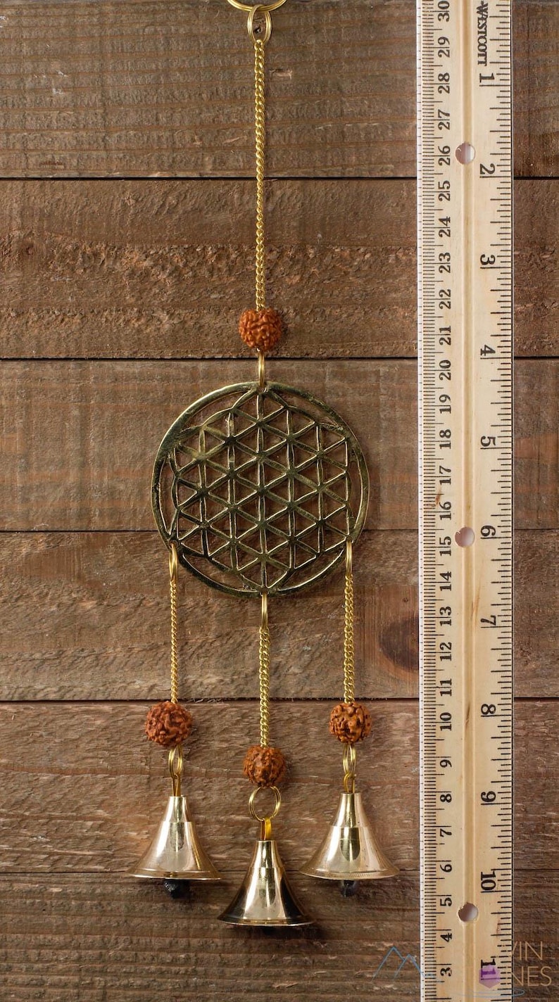 These are small brass wind chimes in the shape of a disc with the "flower of life" sacred geometry design, with bells and Rudraksha beads.