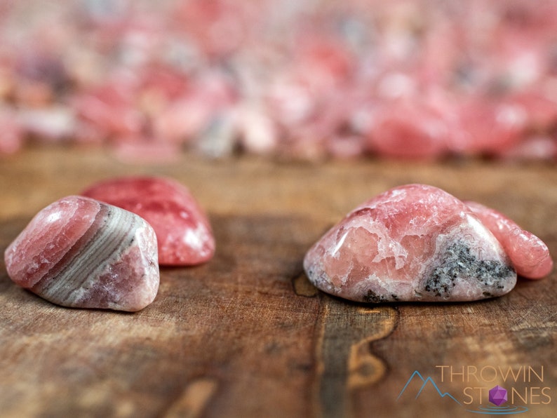 Rhodochrosite Crystal Chips. These stones are light pink to bright pink and often include a white banding. They are great for jewelry making and crystal decor. Each specimen is unique and varies in color, shape, and pattern. Listing has variations.