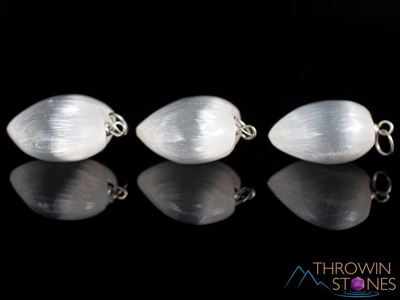 These chatoyant white Selenite crystal pendants are heart shaped, with a silver bail. 
Crystals are nature-made therefore each one is unique in appearance.