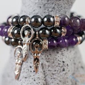 These purple Amethyst and grey Hematite crystal bracelets have round beads strung on elastic.  They feature a silver Goddess Charm.
Crystals are nature-made therefore each one is unique in appearance.