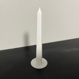 May include: A white 3D printed model of the Washington Monument.