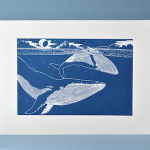 Ballena y cría. Impresión linográfica hecha a mano, escena oceánica de maternidad.