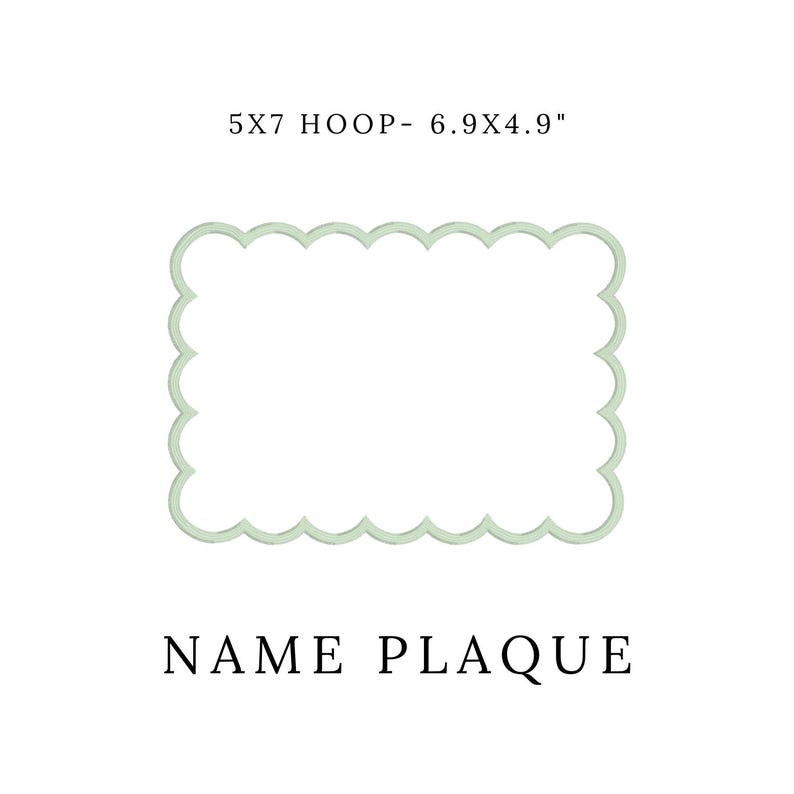 May include: A light green, scalloped-edge name plaque. The text "5X7 HOOP- 6.9X4.9" is above the plaque, and "NAME PLAQUE" is below. The plaque is rectangular and has a decorative border.