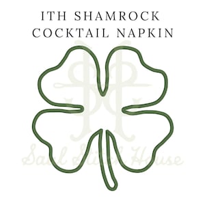May include: An embroidery design featuring a dark green outline of a four-leaf clover. The text ITH SHAMROCK COCKTAIL NAPKIN is printed in black above the clover, with a faint watermark logo visible in the background behind the green shape.