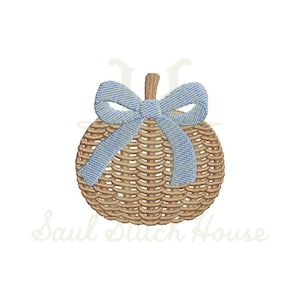 May include: An embroidery design of a tan woven pumpkin with a light blue fabric bow tied at the top stem. The pumpkin features a detailed basket-weave texture rendered in brown thread, with the text Saul Stitch House visible in the background.